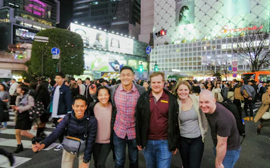 Tourists at Shibuya Crossing, Tokyo, exploring local izakaya bars and Japanese cuisine.