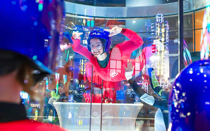 Person experiencing indoor skydiving at iFLY Quest in a wind tunnel.