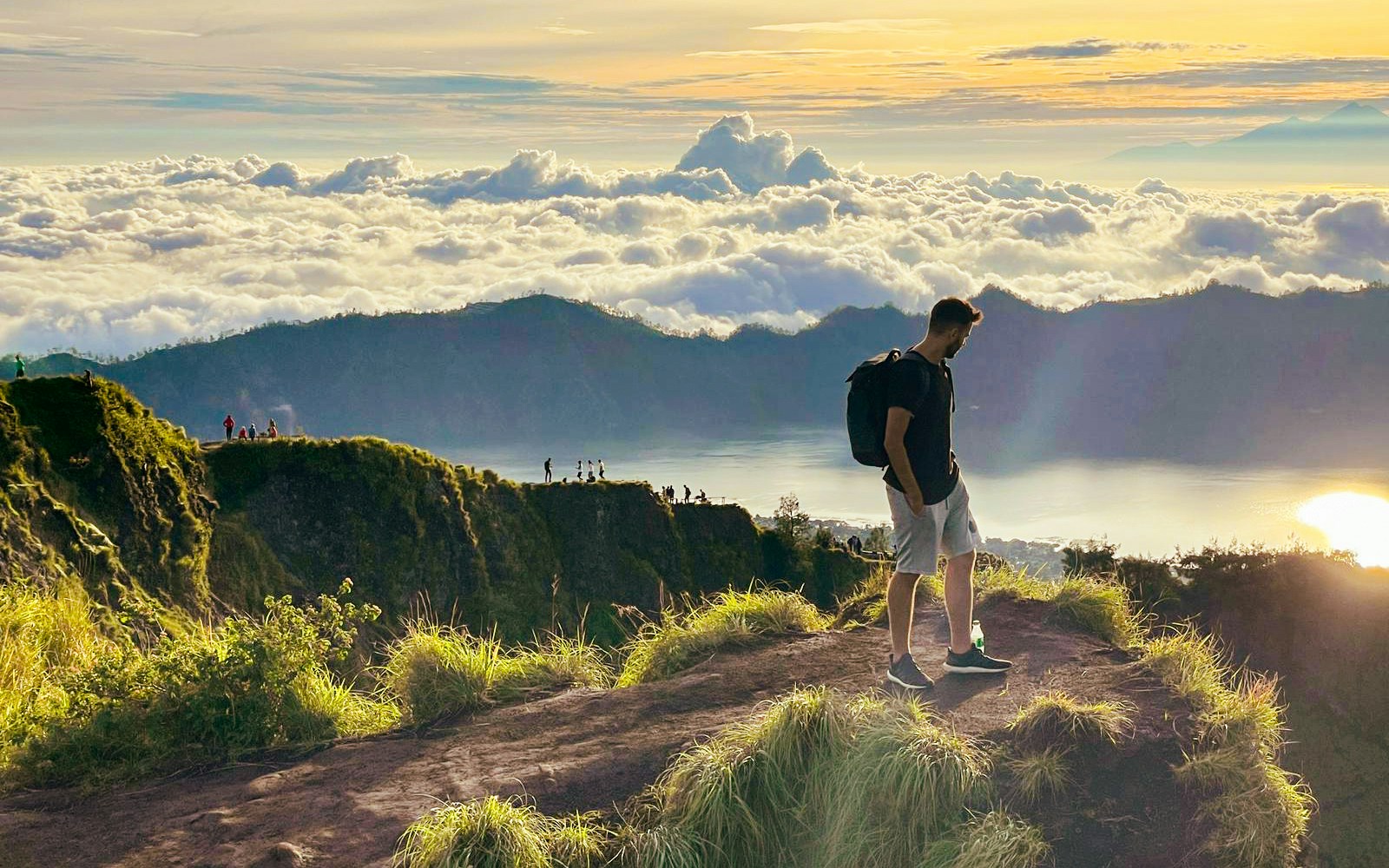Man looking at the view while trekking Mount Batur during sunrise
