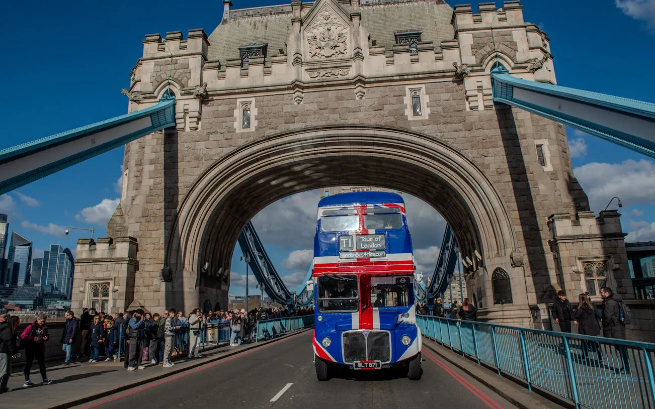 Double-decker bus crossing Tower Bridge on Central London afternoon tea tour.