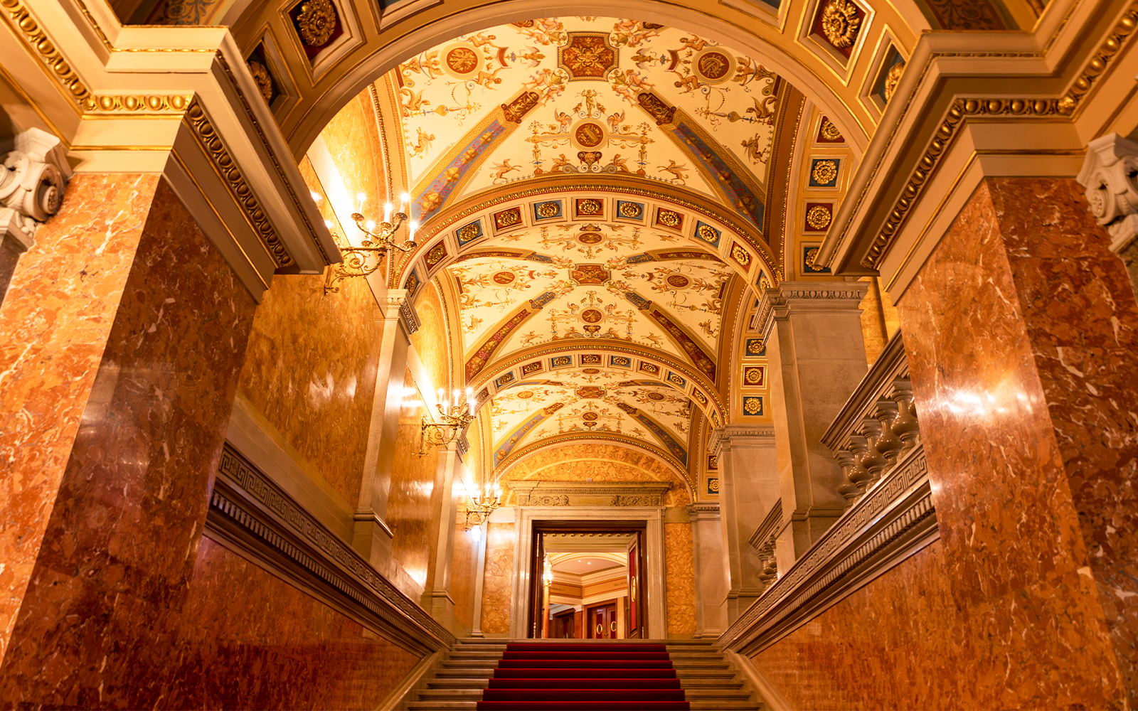 Red marble columns and ornate ceiling in the Hungarian State Opera House, Budapest.