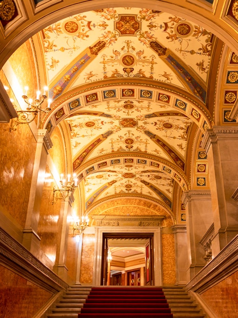 Red marble columns and ornate ceiling in the Hungarian State Opera House, Budapest.