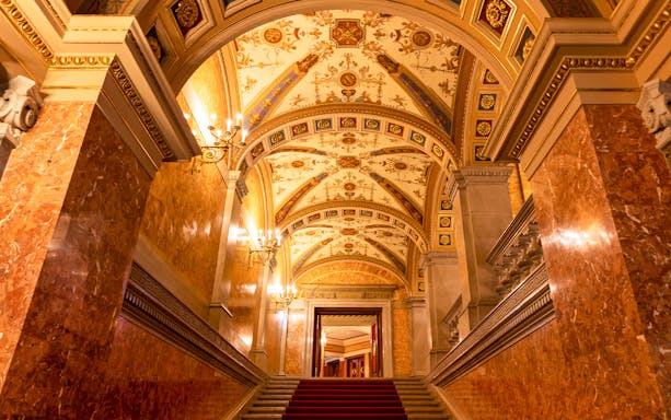 Red marble columns and ornate ceiling in the Hungarian State Opera House, Budapest.