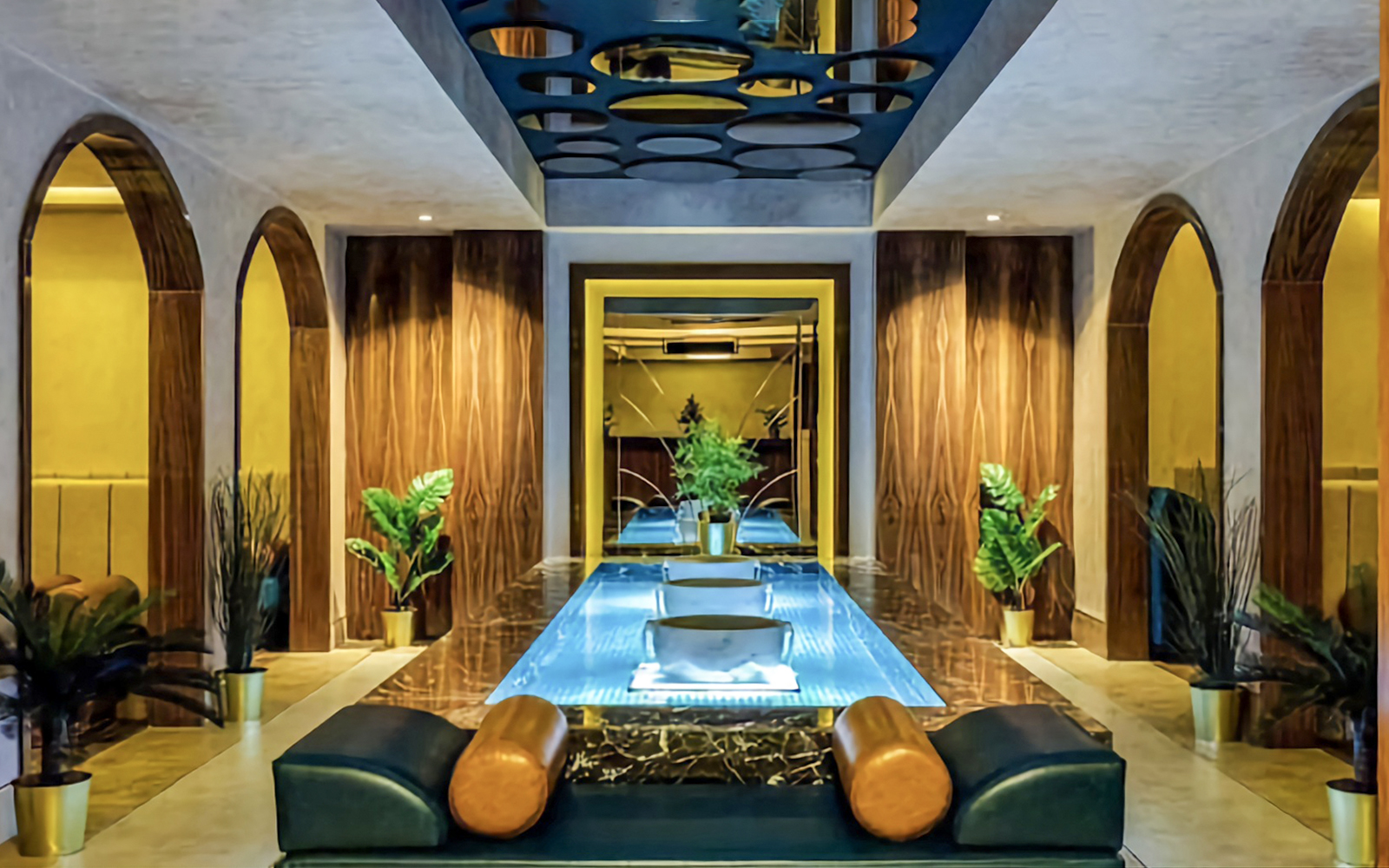 Private Turkish Bath interior with central pool, arched doorways, and decorative plants.