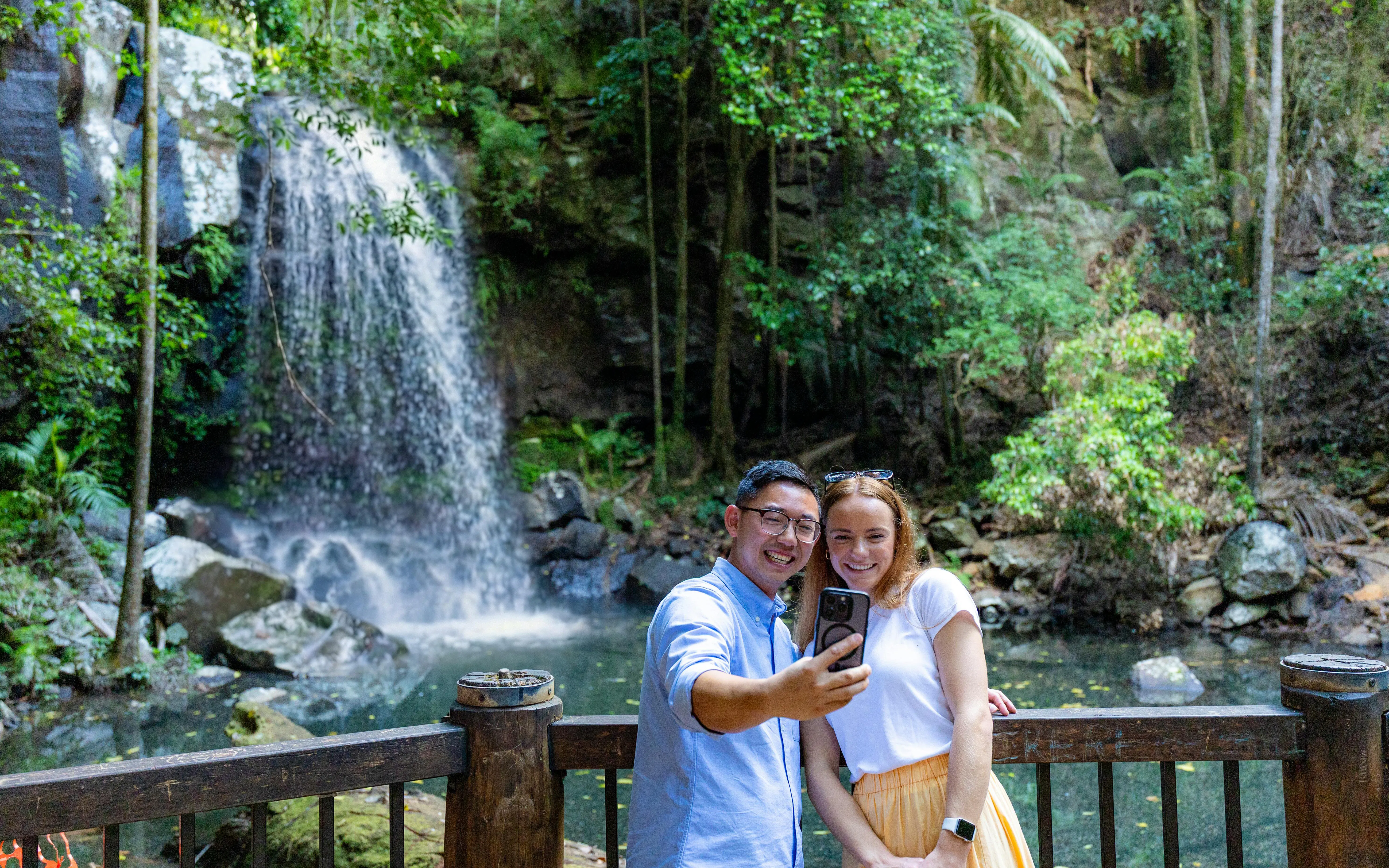 Couple taking a selfie in front of a waterfall at Tamborine Mountain.