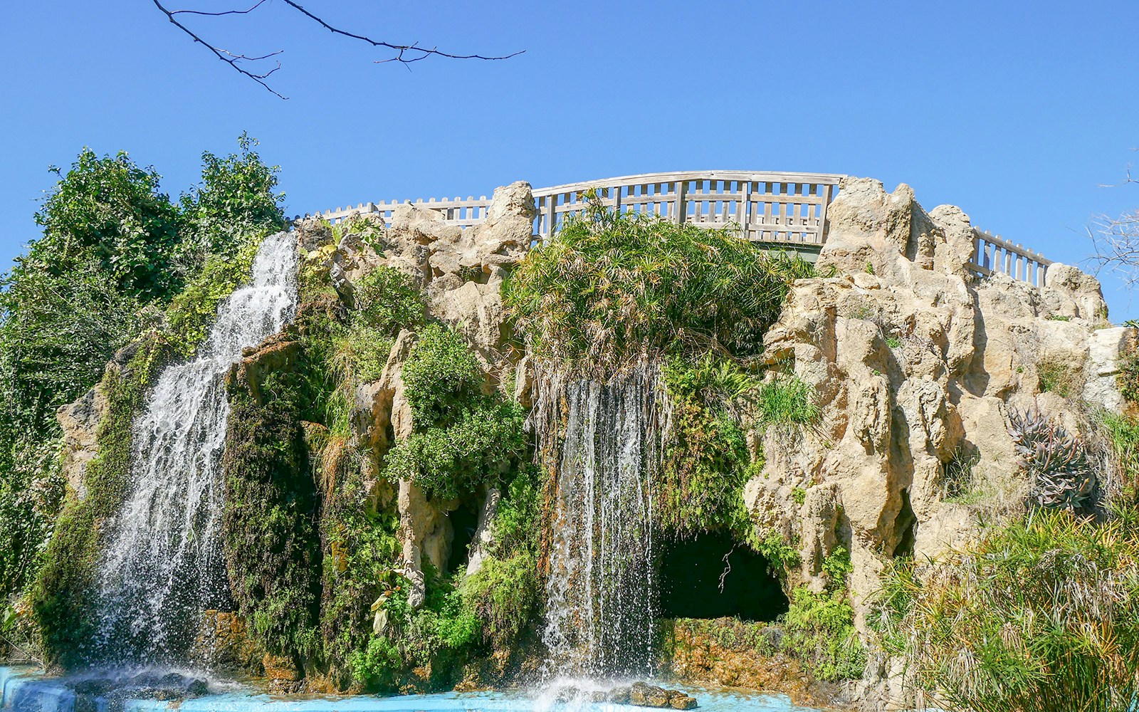 Cascada artificial con puente sobre piedra en el Parque Genovés de Cádiz, España