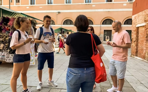 Tourists enjoying a guided street food tour at Rialto Market, Venice.