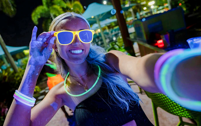 Guest enjoying neon lights at AquaGlow event, Water Country USA.