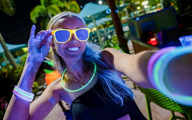 Guest enjoying neon lights at AquaGlow event, Water Country USA.