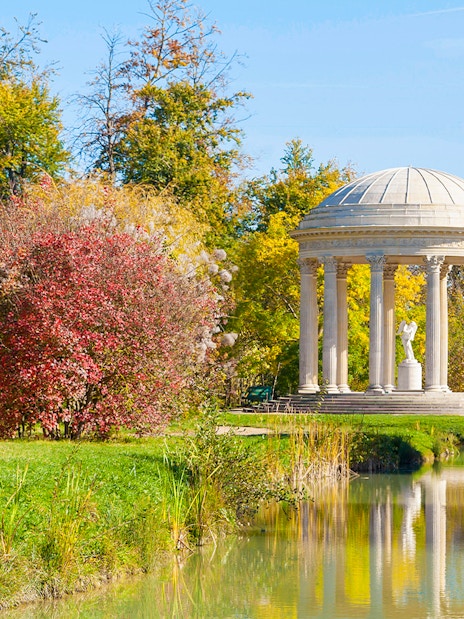 Temple of Love in Trianon gardens, surrounded by trees and reflected in a pond.