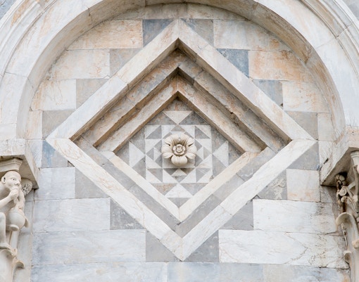 Leaning Tower of Pisa architectural detail with flower motif.