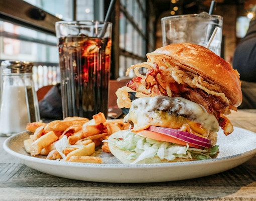 Burger served on a plate with a view of Niagara Falls, Canada in the background.