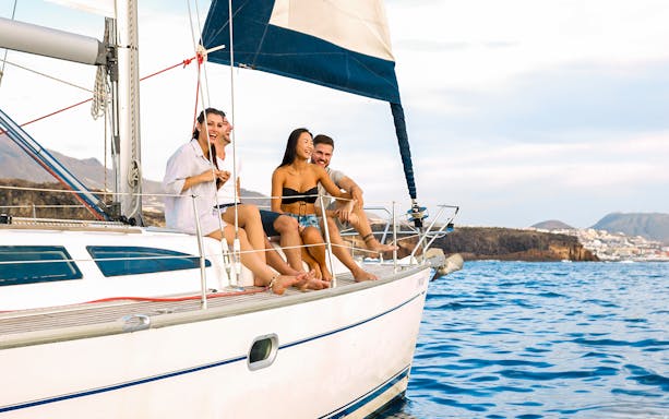 Tourists on a boat enjoying views during Whale & Dolphin Watching Cruise in Tenerife.