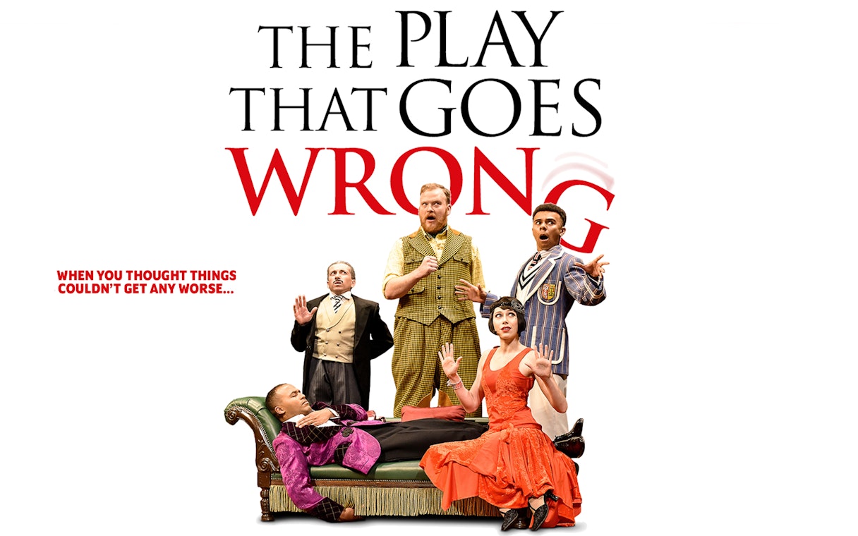 Cast of "The Play That Goes Wrong" in comedic poses on stage.