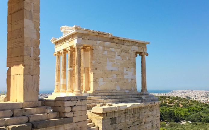 Temple of Athena Nike on the Acropolis, Athens, with cityscape in the background.