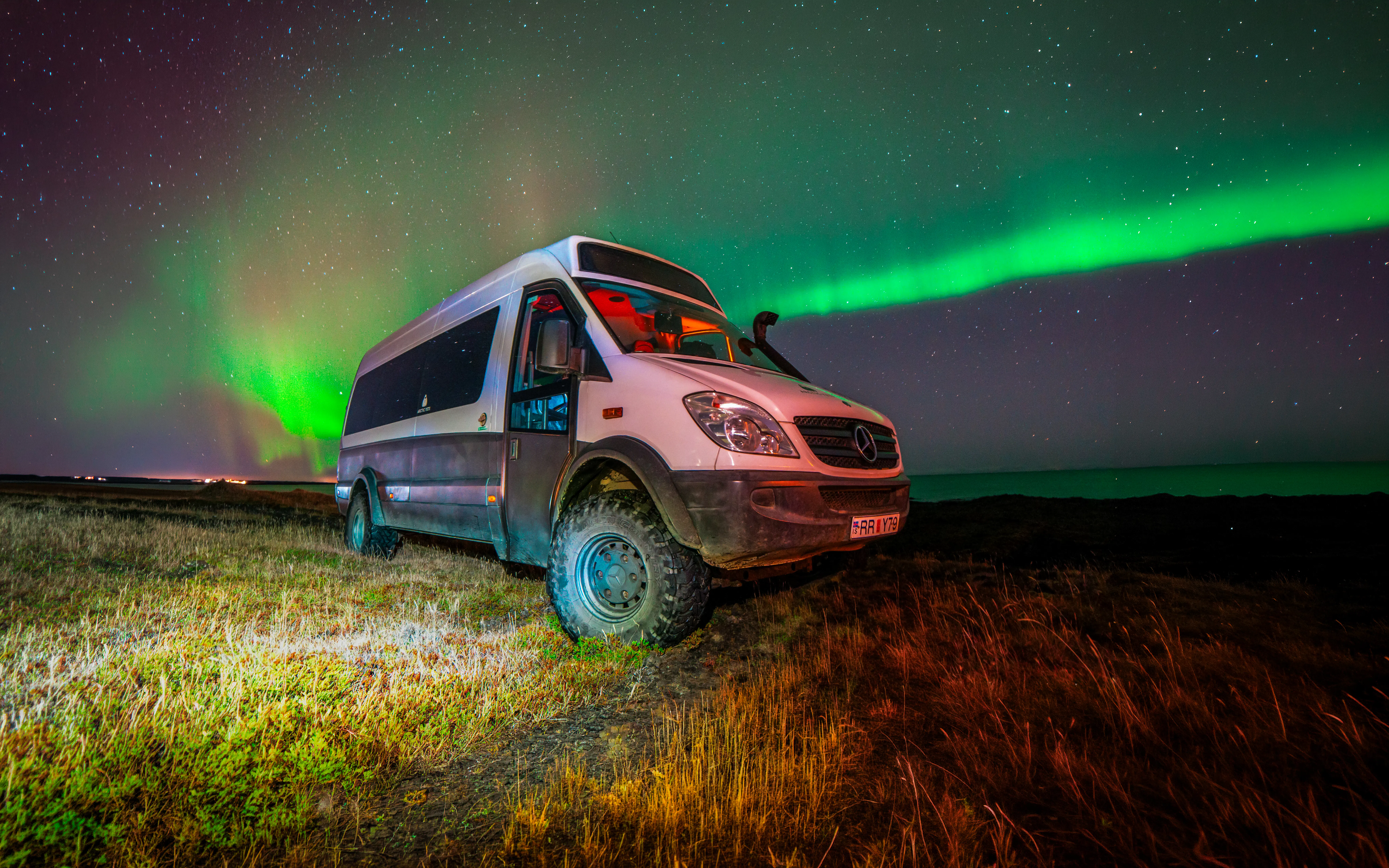 4x4 vehicle under Northern Lights near Reykjavik during private tour.