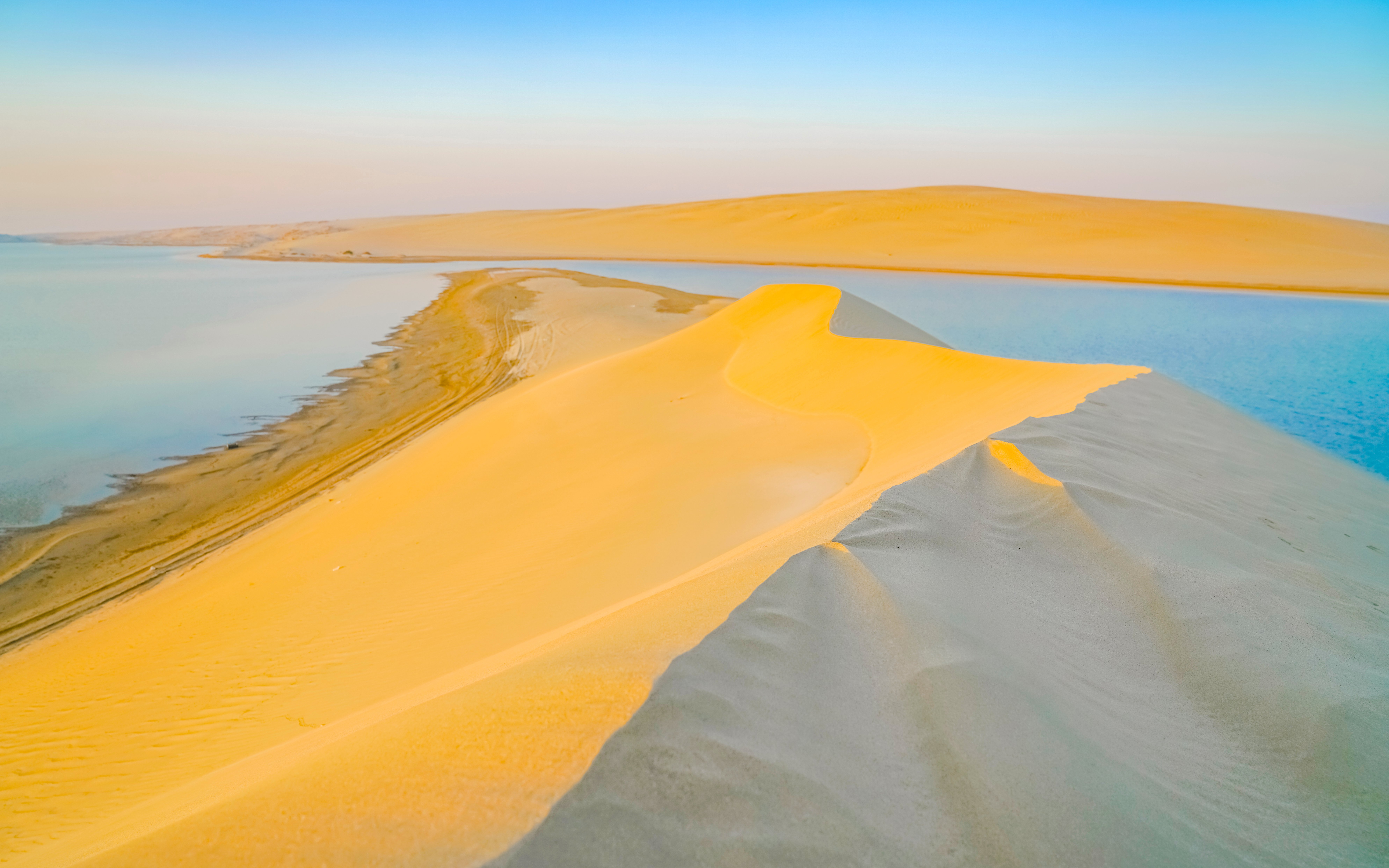 Sand dunes meeting the sea at Khor Al Adaid during sunset, Doha.