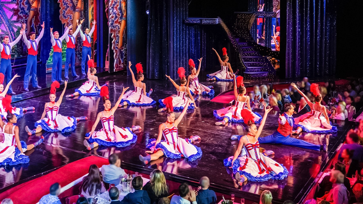 Spettacolo al Moulin Rouge con cena, Parigi, con vivaci ballerine di can-can sul palco.