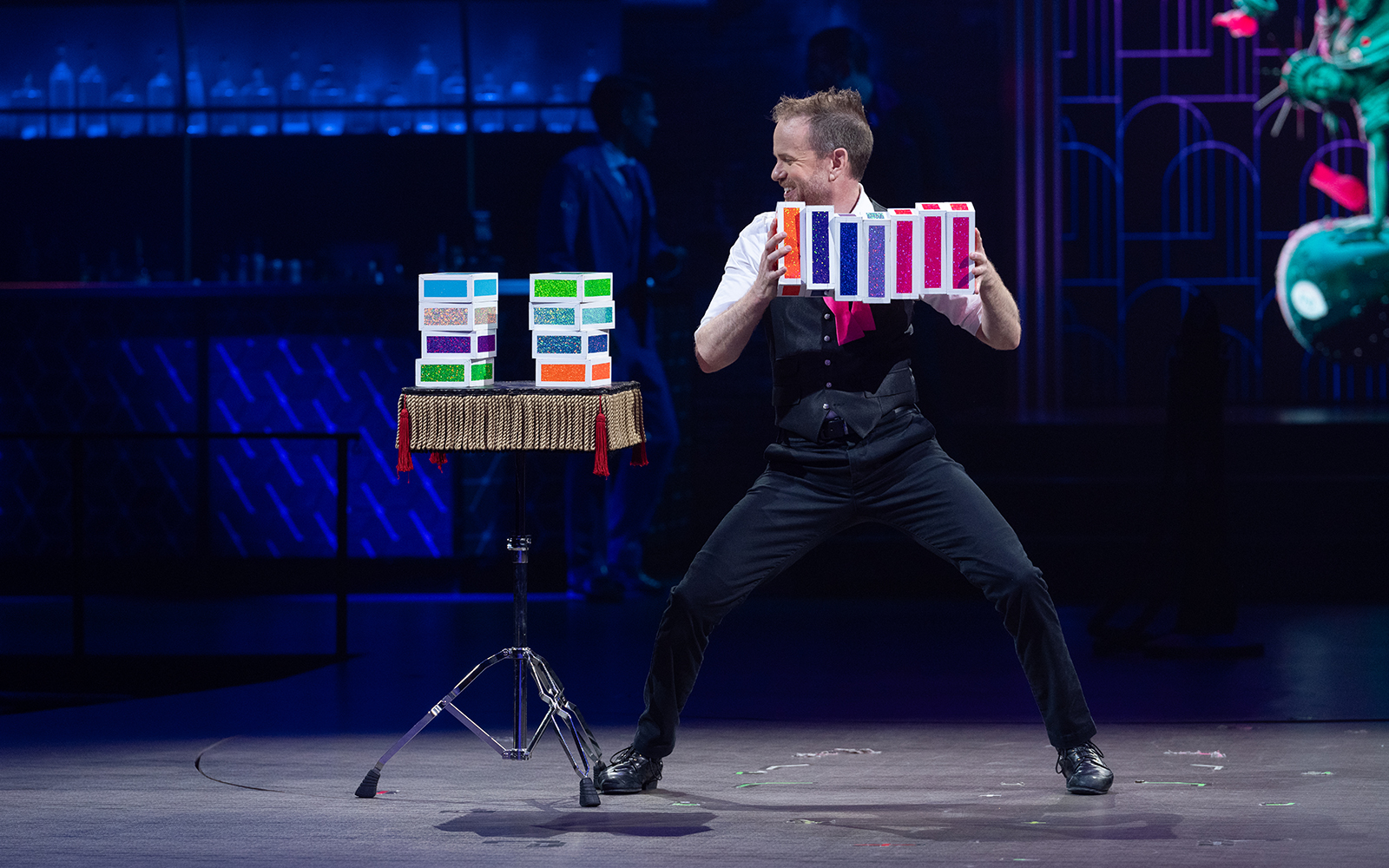 Performer showcasing a colorful card trick at Mad Apple show.
