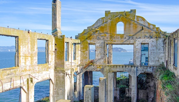 Ruins of the Officers' Club on Alcatraz Island with ocean view in the background.