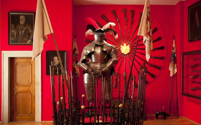 Knight armor display at Lobkowicz Palace Museum with historical weapons in Prague.