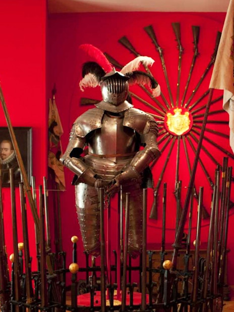 Knight armor display at Lobkowicz Palace Museum with historical weapons in Prague.