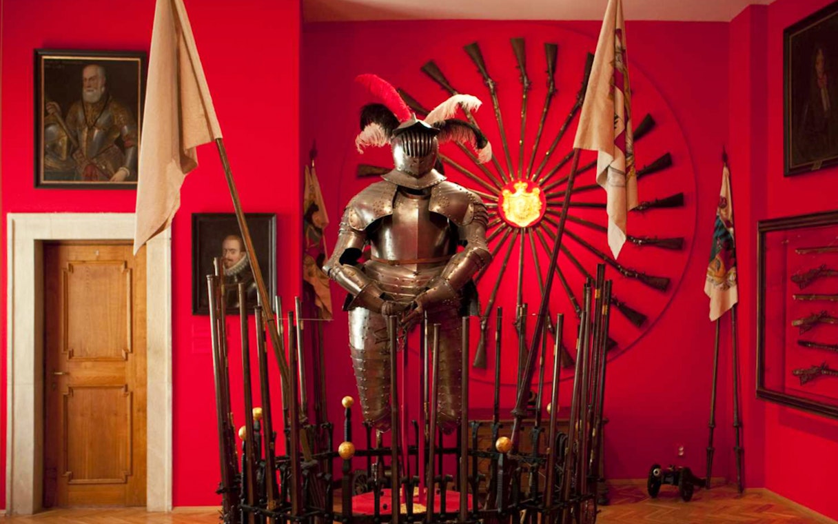 Knight armor display at Lobkowicz Palace Museum with historical weapons in Prague.