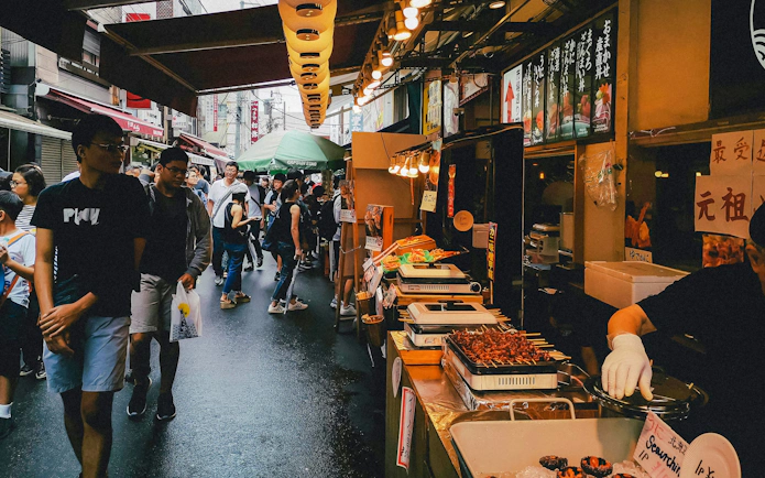 Street food market bustling with people during Tokyo Night Tour.