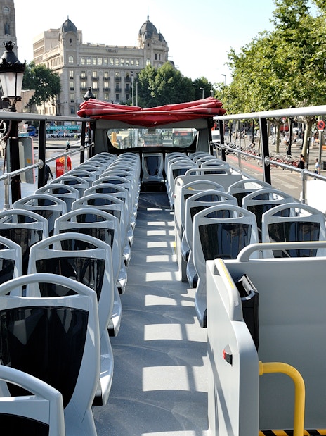 Open-top bus seats on Barcelona City Tour route.