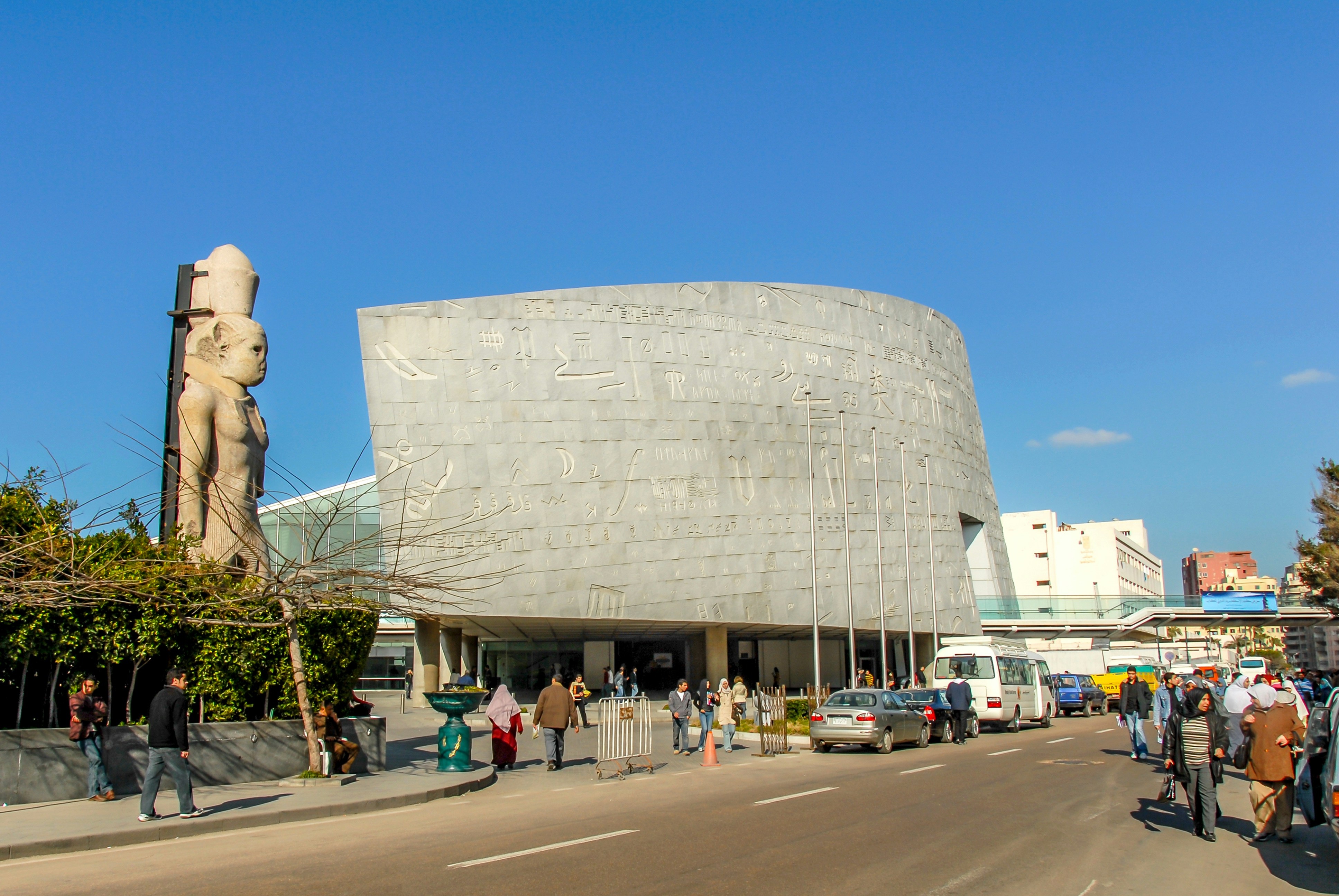 Bibliotheca Alexandrina exterior with hieroglyphic inscriptions and nearby statue in Alexandria, Egypt.