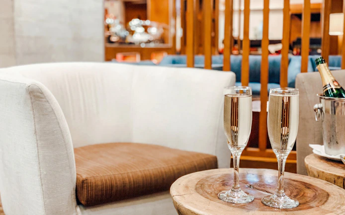Champagne glasses on table at MERA Business Lounge, Terminal 3, Cancún Airport.