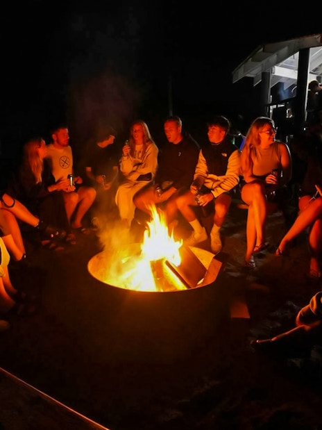 Campfire gathering on Fraser Island, K'gari, with people sitting around the fire.