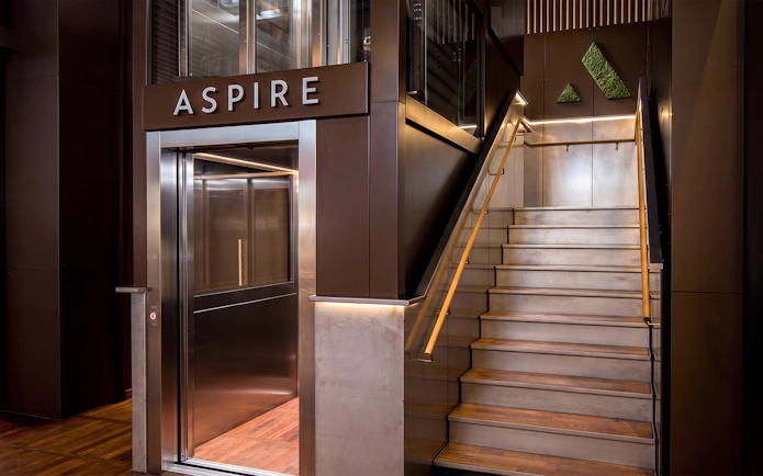 Aspire Lounge entrance with elevator and stairs at Copenhagen Kastrup Airport Terminal 2.