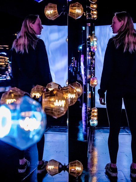 Visitors exploring the colorful light installations at AMAZE Amsterdam.