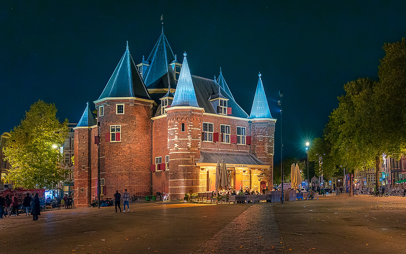 Waag building exterior illuminated at night in Amsterdam.