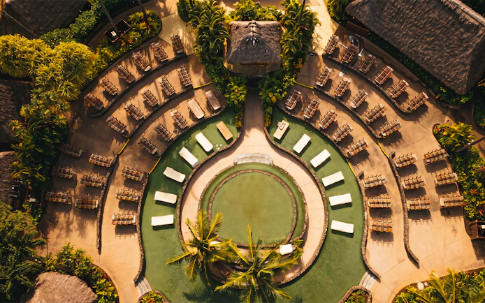 Outdoor seating arrangement at Old Lahaina Luau in Maui, Hawaii, with circular layout and tropical plants.