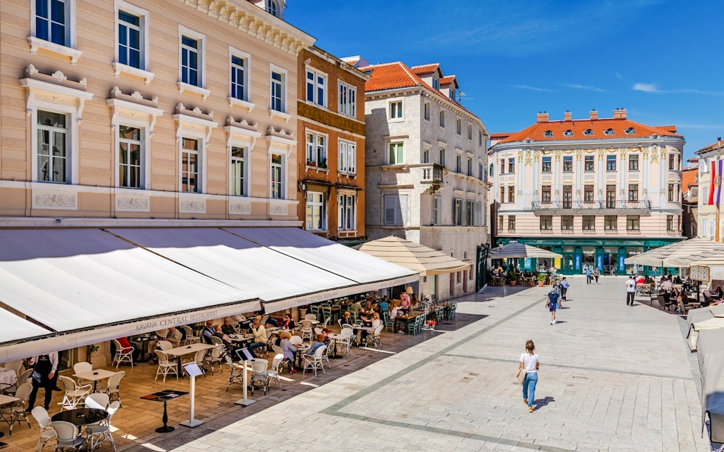 Outdoor cafes and historic buildings at People's Square, Split, Croatia.
