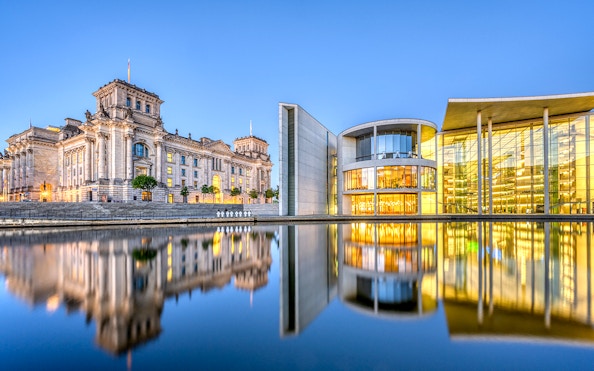 Reichstag and Paul-Loebe-Haus by the Spree River in Berlin at dusk.