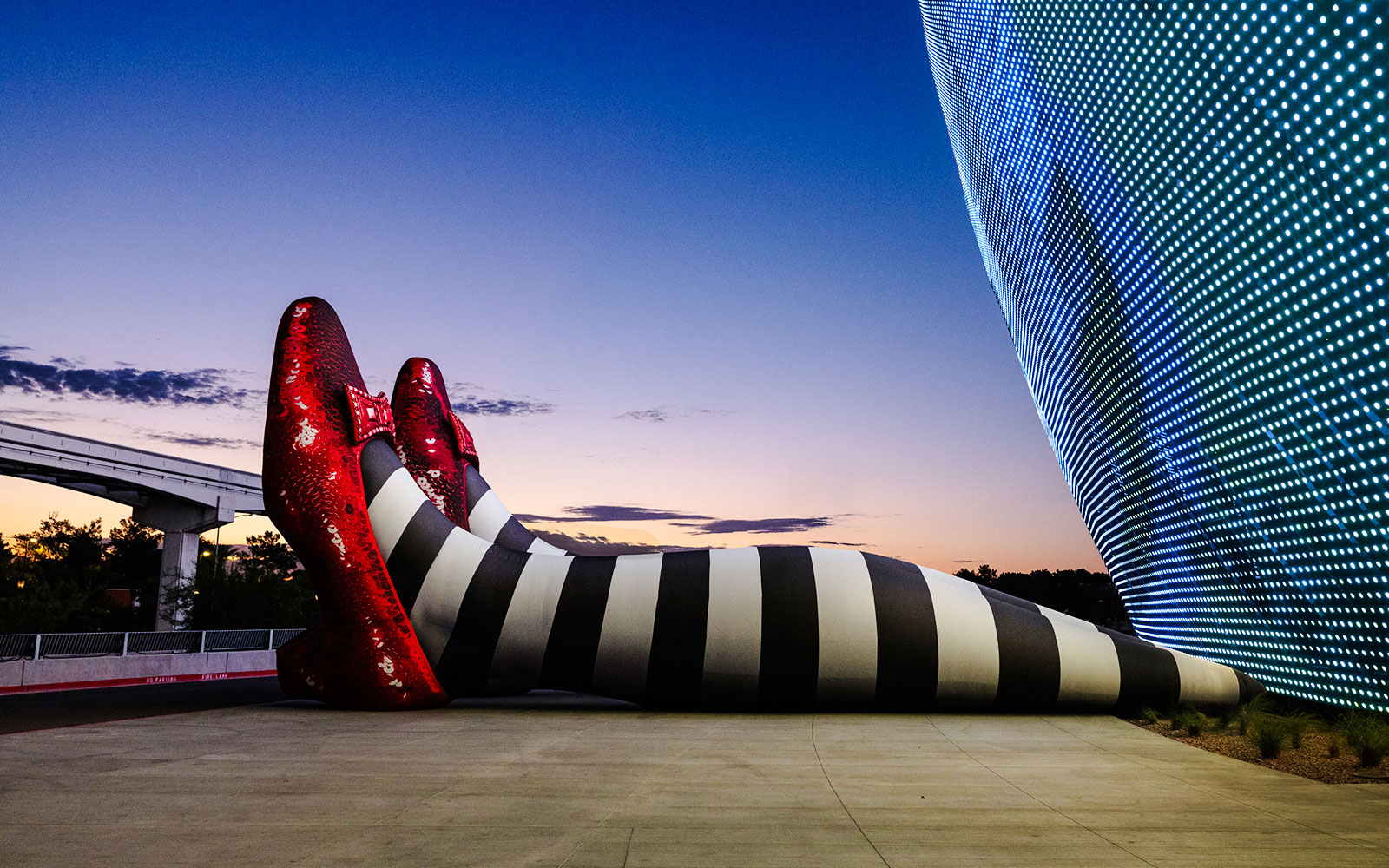 Giant striped legs with red shoes at Sphere, Wizard of Oz theme.