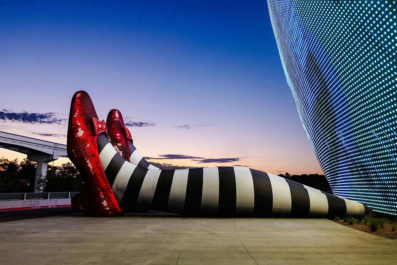Giant striped legs with red shoes at Sphere, Wizard of Oz theme.
