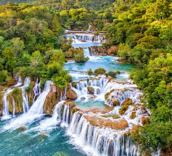 Waterfalls cascading over lush greenery at Krka National Park, Croatia.