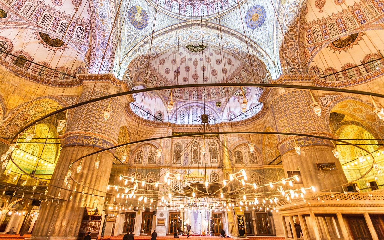 Interior view of the Blue Mosque's ornate ceiling and chandeliers during a guided tour in Istanbul.