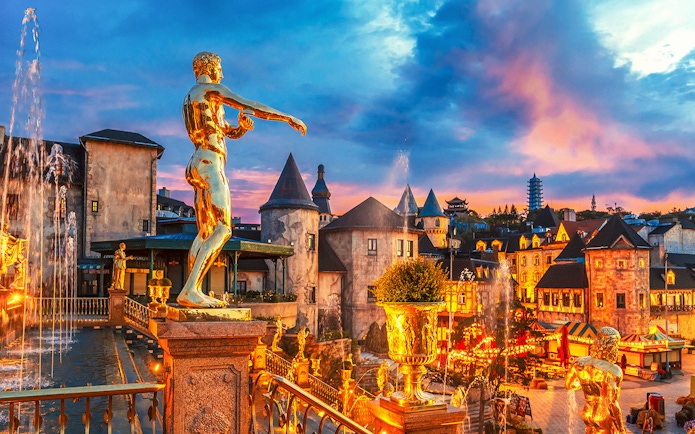 Fountain with golden statues in a French village at Ba Na Hills Park, Da Nang, Vietnam.