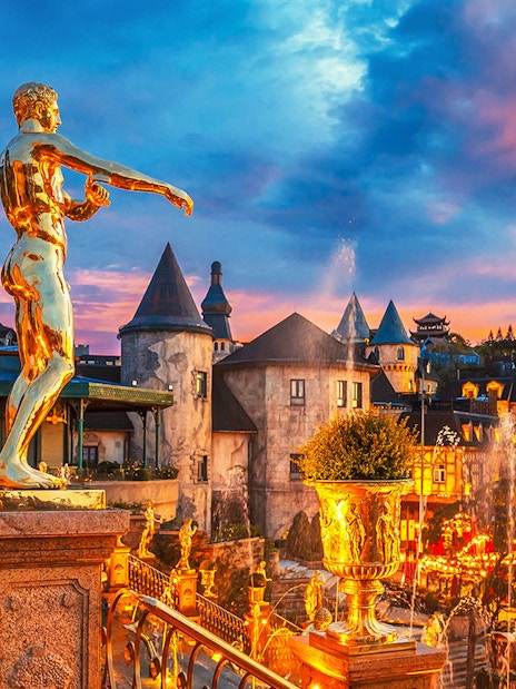 Fountain with golden statues in a French village at Ba Na Hills Park, Da Nang, Vietnam.