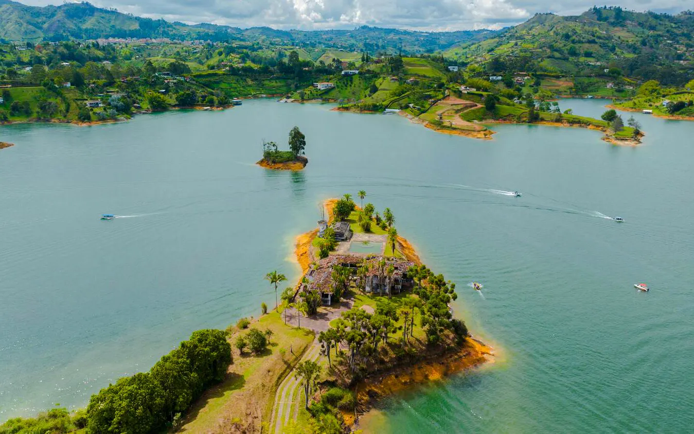 Aerial view of Peñol-Guatapé Reservoir with lush islands and boats in Antioquia, Colombia.