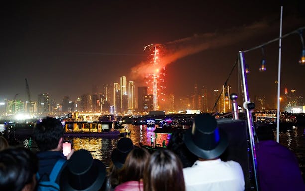 Fireworks over Dubai skyline during New Year's Eve Creek Dhow Dinner Cruise.