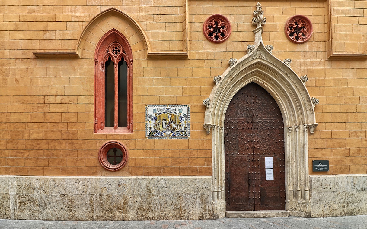 San Nicolas Church ornate wooden door with Gothic arch in Valencia, Spain.
