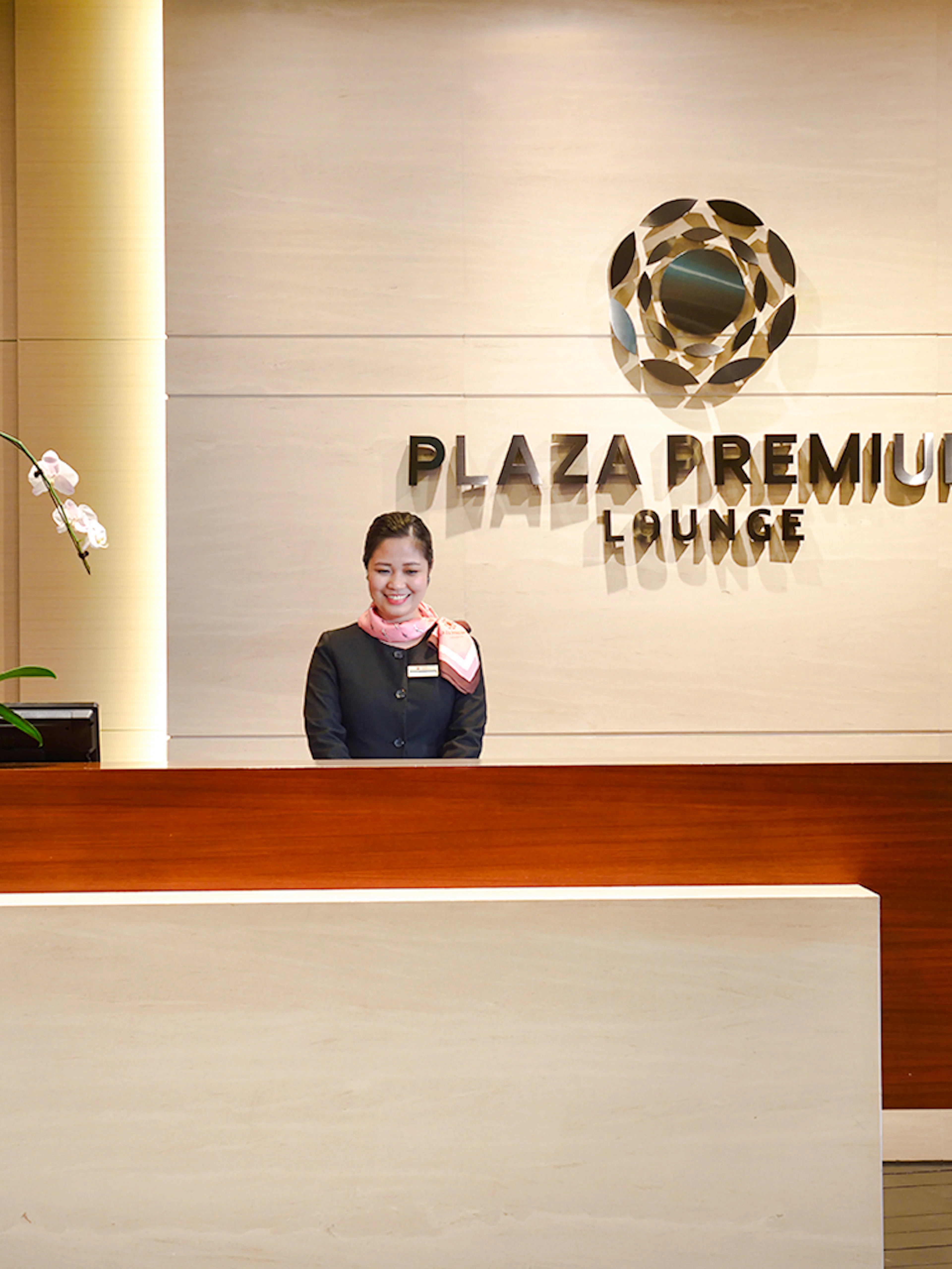 Singapore Plaza Premium Lounge entrance with reception desk and staff.
