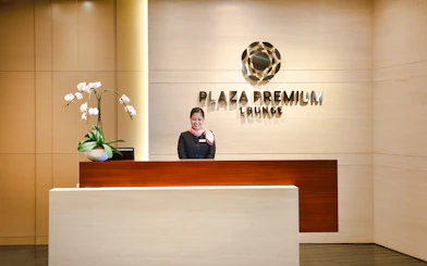 Singapore Plaza Premium Lounge entrance with reception desk and staff.