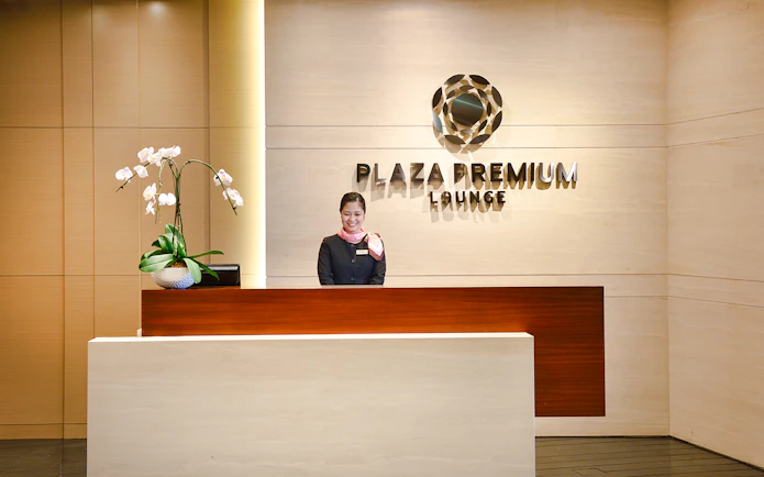 Singapore Plaza Premium Lounge entrance with reception desk and staff.